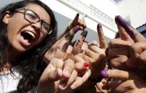 Tunisians show their ink-stained fingers after casting their votes, in Tunis