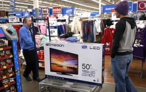 A Walmart employee helps a customer with a 50' TV on sale for $218 on Black Friday in Broomfield, Colorado