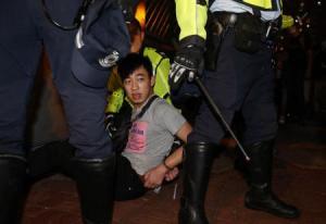 A protester is detained during a confrontation with the police as protesters try to block a side street at Mongkok shopping district in Hong Kong