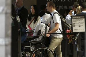 Herzog, a doctoral student at Max Planck Society, pushes 'Athena', the first 'humanoid' robot to fly as a passenger, as  they prepare to board a Lufthansa commercial airline flight to Frankfurt, Germany at Los Angeles International Airport