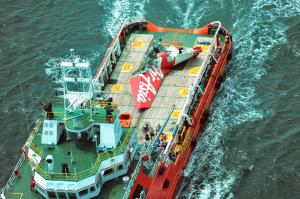 An aerial photo shows a tail section (C) of the AirAsia flight QZ8501 on the deck of a Crest Onyx ship as the search for black boxes of the aircraft continues in the Java sea