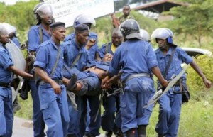 Riot policemen evacuate their colleague (C) after he was injured during clashes with protesters against the ruling CNDD-FDD party"s decision to allow Burundian President Pierre Nkurunziza to run for a third five-year term in office, in Bujumbura