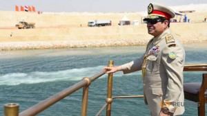 Egyptian President Abdel Fattah al-Sisi stands in boat on the Suez Canal as he attends the celebration of an extension of the Suez Canal in Ismailia